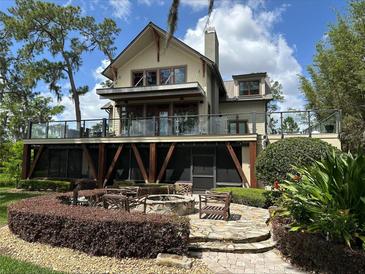 Inviting backyard featuring a stone patio with a fire pit and outdoor seating, perfect for entertaining at 8907 Trout Rd, Orlando, FL 32836