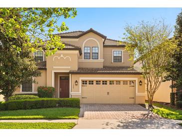 Charming two-story home with a well-maintained lawn, a tile roof, and an attached two-car garage at 1405 Thunderbird Rd, Davenport, FL 33896