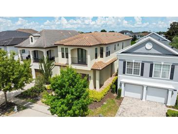 Beautiful two-story home with a clay tile roof and a well-manicured lawn and landscaping at 1539 Corolla Ct, Reunion, FL 34747