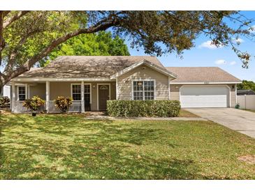 Charming single-story home with a well-manicured lawn, cozy front porch, and attached two car garage at 1563 Dess Dr, Orlando, FL 32818