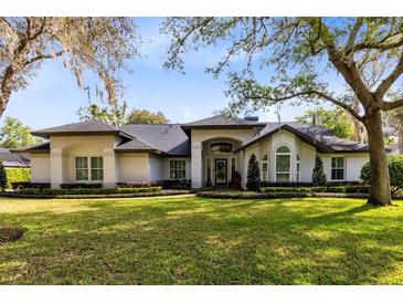 Stunning single-story home featuring mature trees, lush landscaping, and a well-manicured lawn at 1682 Wingspan Way, Winter Springs, FL 32708