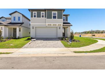 Charming two-story home with a two car garage, brick paver driveway and a well manicured lawn at 1912 Archer Dr, Minneola, FL 34715
