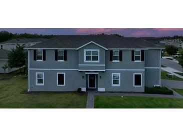 Two-story home featuring a grey exterior, well-manicured lawn, and classic window trim at 2252 Emerald Springs Dr, Apopka, FL 32712