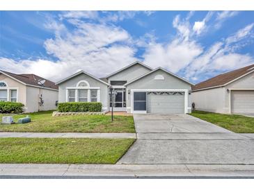 Charming single-story home features a well-maintained lawn and a two-car garage at 2607 Quail Pond Way, Kissimmee, FL 34743