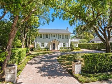 Charming home with manicured lawn, brick driveway, and lush landscaping creating curb appeal at 266 Chase Ave, Winter Park, FL 32789