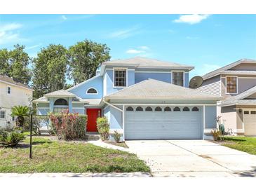 Charming two-story blue home featuring a front-facing two car garage and a vibrant red front door at 271 Morning Glory Dr, Lake Mary, FL 32746