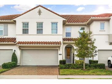 Charming townhouse with a red tile roof, brick driveway and well manicured landscaping at 2710 Bolzano Dr, Apopka, FL 32712