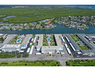 Overhead shot of a waterfront condominium complex with pools, carports, and lush surroundings on the coast at 325 N Causeway # D-206, New Smyrna Beach, FL 32169