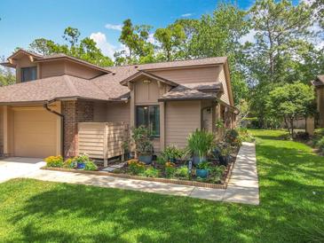 Charming home features a well-manicured lawn, garden and inviting walkway, creating a welcoming curb appeal at 419 Newton Pl, Longwood, FL 32779