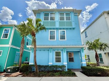 Charming blue two-story home with a well-manicured lawn and a blue sky backdrop at 7968 Shaker St, Kissimmee, FL 34747