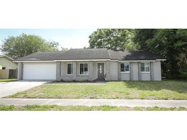 Charming single-story home featuring a well-manicured lawn and a gray stone exterior at 854 Escabar Dr, Altamonte Springs, FL 32714