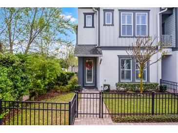 Charming townhome with landscaped front yard and black metal fence, welcoming entrance with wreath at 1010 Lychee Ct, Lake Mary, FL 32746
