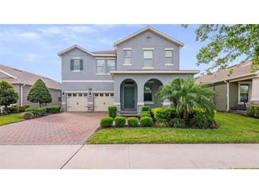 Charming two-story home with a well-manicured lawn and a three-car garage at 10133 Merrymeeting Bay Dr, Winter Garden, FL 34787