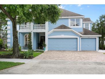 Charming two-story light blue home with well-manicured lawn and a three-car garage at 1128 Brantley Estates Dr, Altamonte Springs, FL 32714