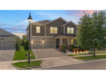 Charming two-story home boasts a well-manicured lawn, a two-car garage, and inviting outdoor lighting at 12048 Imaginary Way, Orlando, FL 32832