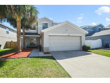 Charming two-story home with a two car garage and a well-manicured front yard with beautiful landscaping at 13208 Canna Lily Dr, Orlando, FL 32824