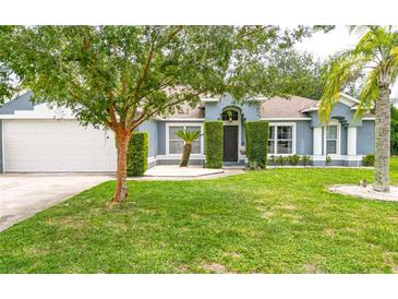 Charming single-story home with a lush green lawn, mature trees, and a well-manicured landscape at 157 Long Pine Dr, Deltona, FL 32725