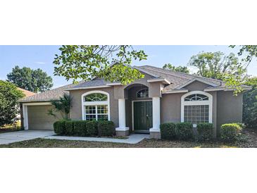 Charming single-story home featuring a well-manicured lawn, inviting front door, and attached two-car garage at 2025 Claremont Dr, Deltona, FL 32725