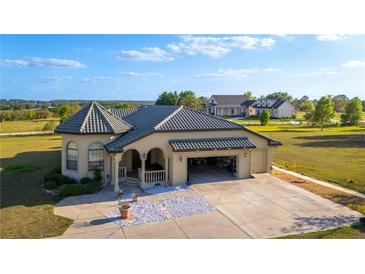Charming home with a three car garage, and a beautiful tile roof, on a well-manicured lot at 20951 County Road 561, Clermont, FL 34715