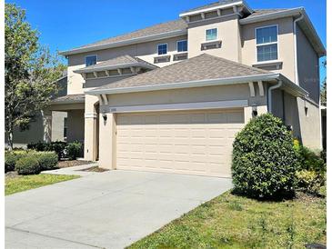 Two-story home with a neutral color scheme, a driveway, and a two-car garage at 3301 Bethpage Loop, Mount Dora, FL 32757