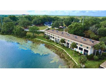 Waterfront condo complex featuring well-maintained landscaping and serene lake views in a scenic setting at 408 E Orlando Ave # 2A, Ocoee, FL 34761