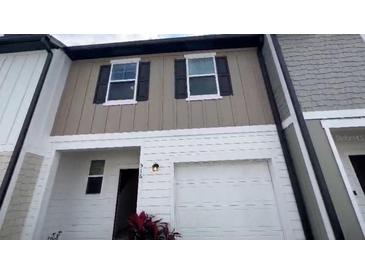 Two-story townhome featuring a one-car garage, modern siding, and a well-maintained front exterior at 516 Madison Dr, Davenport, FL 33837