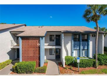 Charming two-story condo featuring a decorative privacy wall and beautiful, mature landscaping at 6 Escondido Cir # 64, Altamonte Springs, FL 32701