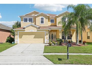 Charming two-story home featuring a well-manicured lawn, a two-car garage, and a beautifully landscaped yard at 14819 Braywood Trl, Orlando, FL 32824