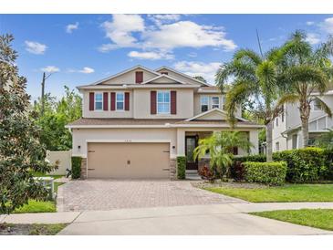 Charming two-story home featuring a spacious garage, landscaped yard, and a welcoming front porch at 1613 Sapphire Star Dr, Oviedo, FL 32765