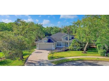 Charming single-Gathering home featuring a paver driveway, attached garage, and lush landscaping at 203 Red Bud Ct, Lake Mary, FL 32746