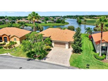Beautiful single-story home with a manicured lawn, brick driveway, and a scenic waterfront view at 313 Sorrento Rd, Poinciana, FL 34759