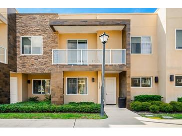 Charming two-story townhome with a decorative stone facade, balcony and well-maintained landscaping at 3228 Brasilia Ave, Kissimmee, FL 34747