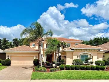 Stunning two-story home with a tile roof, palm trees, beautiful landscaping and a three car garage at 4120 Juliana Lake Dr, Auburndale, FL 33823