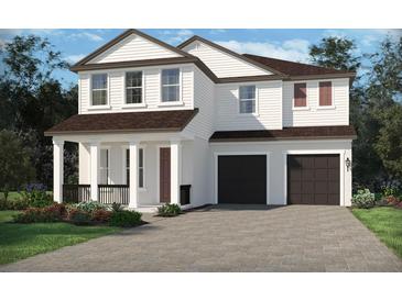 Charming two-story home with white siding, a covered porch, and a two-car garage at 5319 Citrus Leaf Blvd, Winter Garden, FL 34787