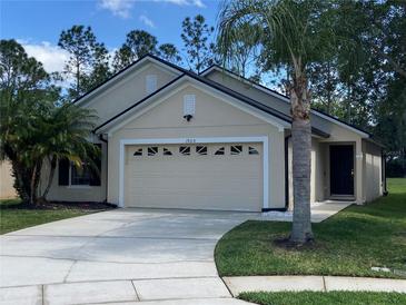 Charming single-story home with a two-car garage, nice landscaping and a well-manicured lawn at 1920 Commander Way, Kissimmee, FL 34746