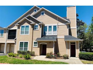 Inviting townhouse with beige siding, chimney, well-kept lawn and two front doors at 1980 Erving Cir # 107, Ocoee, FL 34761