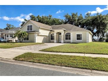 Charming single-story home featuring a well-manicured lawn and a brick driveway at 2425 Rambling Oaks Way, Kissimmee, FL 34746