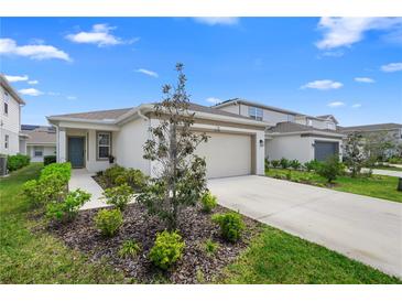 Inviting single-story home with a well-maintained lawn, two-car garage, and charming blue front door at 5298 Royal Point Ave, Kissimmee, FL 34746
