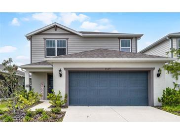 Charming two-story home with a well-manicured lawn and a two-car garage, creating an inviting curb appeal at 5329 Royal Point Ave, Kissimmee, FL 34746