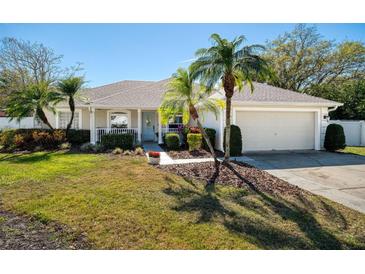 Charming single-story home with lush landscaping, attached garage, and inviting front porch at 1624 Malcolm Pointe Dr, Winter Garden, FL 34787