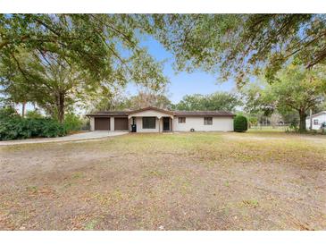 Charming single-story home with a two-car garage and a spacious front yard shaded by mature trees at 16336 Old Cheney Hwy, Orlando, FL 32833