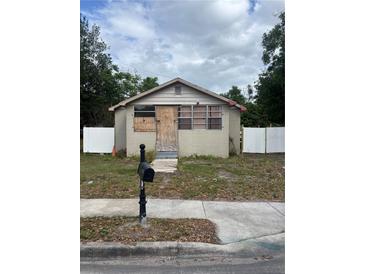 Small one story home with boarded up windows and door and white fence surrounding the lot at 1905 S Westmoreland Dr, Orlando, FL 32805