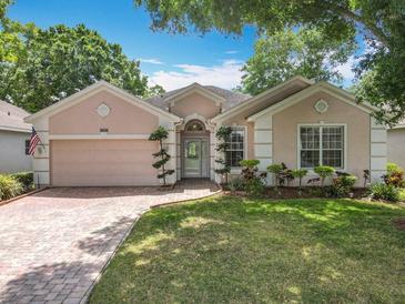 Charming one-story home with a brick driveway and manicured lawn at 2409 Twickingham Ct, Clermont, FL 34711
