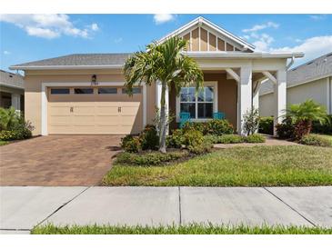 Charming home with a beige exterior, well-maintained landscaping, brick driveway, and a cozy porch area at 2789 Southland St, St Cloud, FL 34772