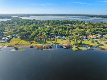 Stunning aerial view of lakefront home with lush landscaping and private dock access at 2926 Marquesas Ct, Windermere, FL 34786