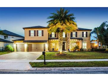Stunning two-story home with a three-car garage, mature landscaping, and inviting curb appeal at twilight at 427 Egret Place Dr, Winter Garden, FL 34787