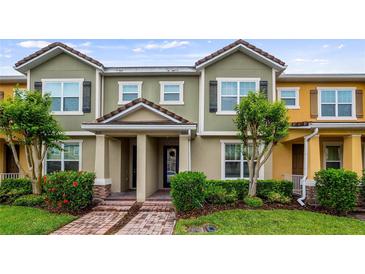 Charming townhome featuring a well-maintained lawn, brick walkway and neutral color scheme at 7660 Ripplepointe Way, Windermere, FL 34786