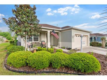 Charming single-story home with lush landscaping, front porch, and attached two car garage at 8205 Sw 78Th Terrace Rd, Ocala, FL 34476