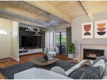 Inviting living room boasts beamed ceilings, fireplace, and sleek, modern furniture for relaxation at 102 Fairway Dr # 102, Longwood, FL 32779