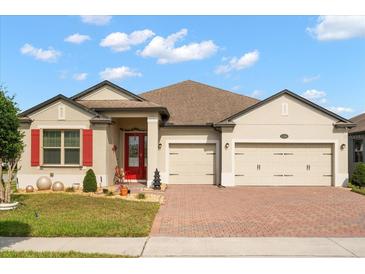 Charming single-story home featuring a manicured lawn, brick driveway, and a two-car garage at 1199 Playa Del Sol Ln, St Cloud, FL 34771